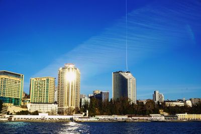 River in city against clear blue sky