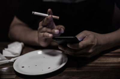 Close-up of man using smart phone at home