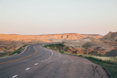 Road amidst desert against clear sky