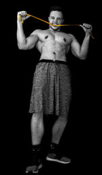Portrait of shirtless man standing against black background