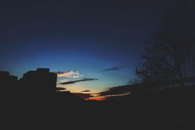 Silhouette trees against sky at sunset