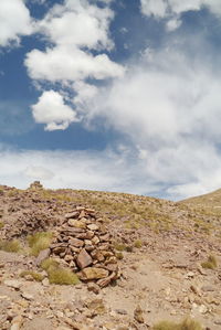 Stack of rocks on landscape against sky