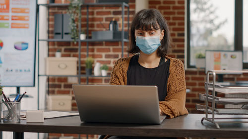 Businesswoman wearing mask working at office