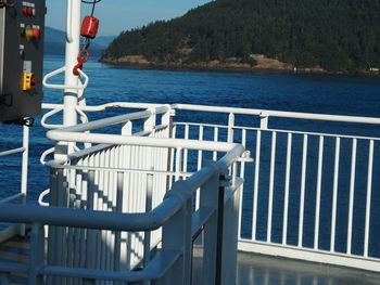 Railing by sea against mountain