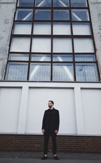 Full length of man looking through window in building