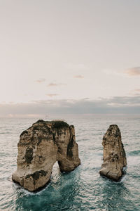 Rocks in sea against sky