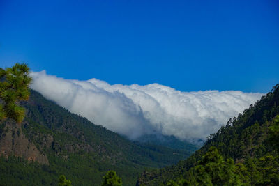 Scenic view of mountains against blue sky