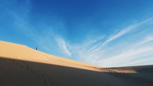 Scenic view of desert against blue sky