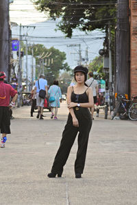 Full length of smiling woman standing on street