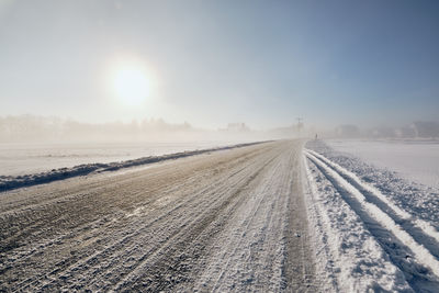 Scenic view of snowy field against sky during winter