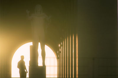 Rear view of silhouette man standing in illuminated corridor