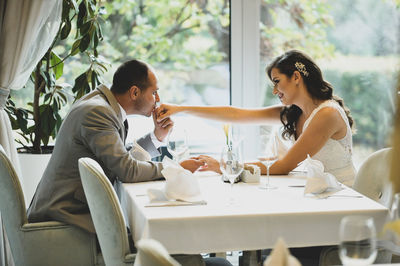 Young wedding couple sitting on table