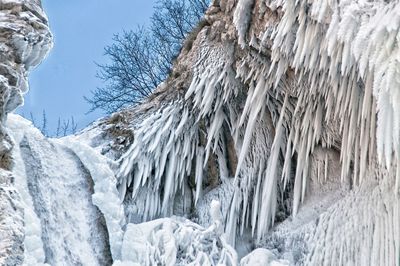 Close-up of icicles on cliff against mountains