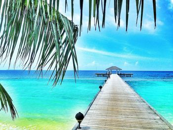 Pier over sea against blue sky