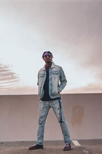 Full length of young man standing against sky during sunset