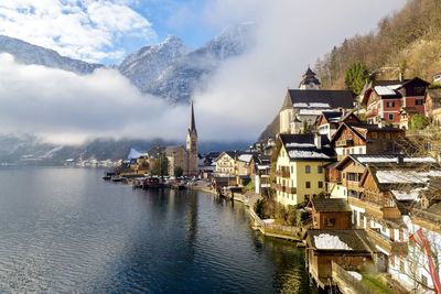 Panoramic view of townscape by lake and buildings against sky