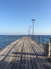 Pier on sea against blue sky