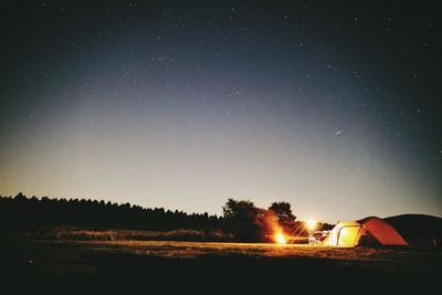 Scenic view of illuminated field against clear sky at night