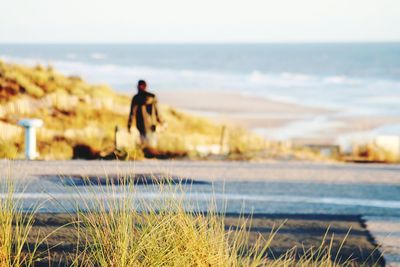 Man at beach against sky