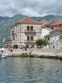 View of buildings on waterfront against cloudy sky