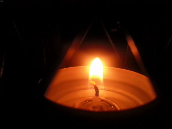 Close-up of lit candle in dark room