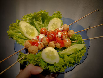 Close-up of hand holding meatballs satay