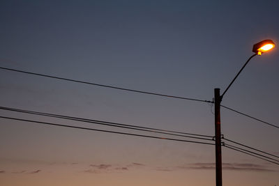 Low angle view of electricity pylon against clear sky