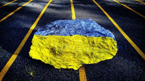 Yellow paint on rock at street