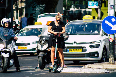 Rear view of people walking on street in city