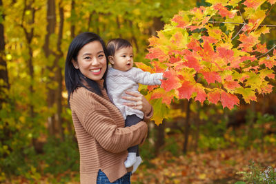 Mother and daughter in park during autumn