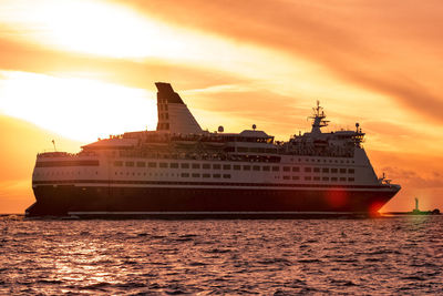 Ship sailing on sea against sky during sunset