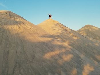 Man on desert against clear sky