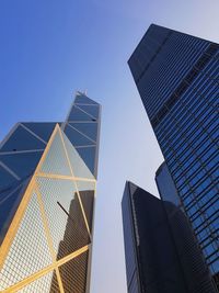 Low angle view of modern buildings against clear blue sky