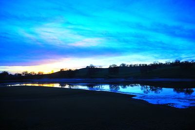 Scenic view of lake against sky at sunset