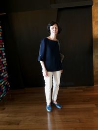 Portrait of woman standing on hardwood floor