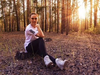 Portrait of young woman sitting in forest