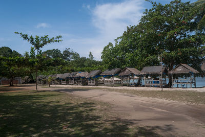 Houses by trees against sky