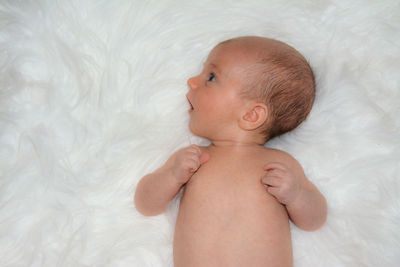 Close-up of baby girl lying on bed