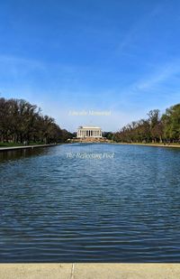 Scenic view of lake by building against blue sky