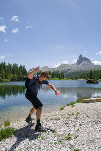 Man throwing stone in the water in the lake