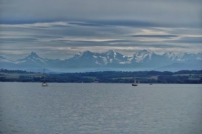 Scenic view of sea and mountains against sky