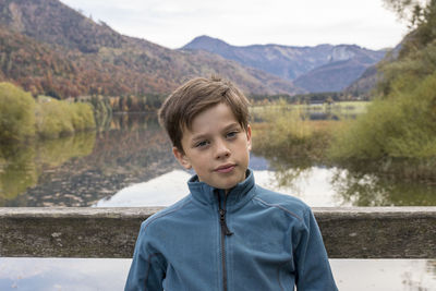 Portrait of boy standing against lake