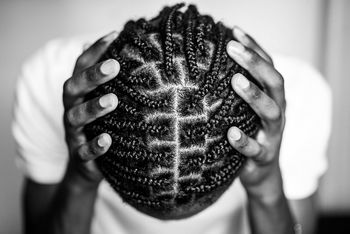 Close-up of braided hair man hand on head