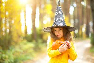 Young woman wearing hat standing in forest