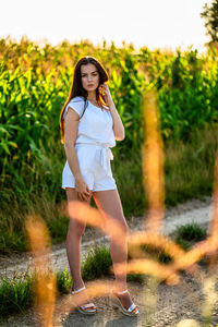 Portrait of young woman standing on field