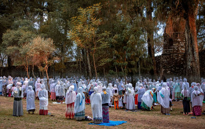 People in traditional clothing standing at amidst trees at park