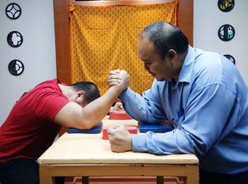 People arm wrestling at table