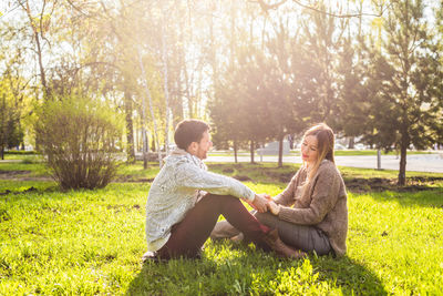 Couple sitting on field in park