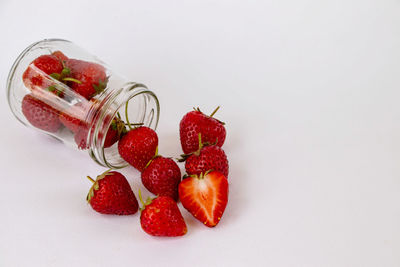 High angle view of strawberries on glass against white background