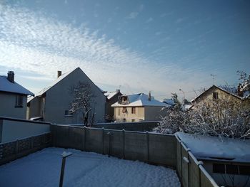 Houses and buildings against sky during winter